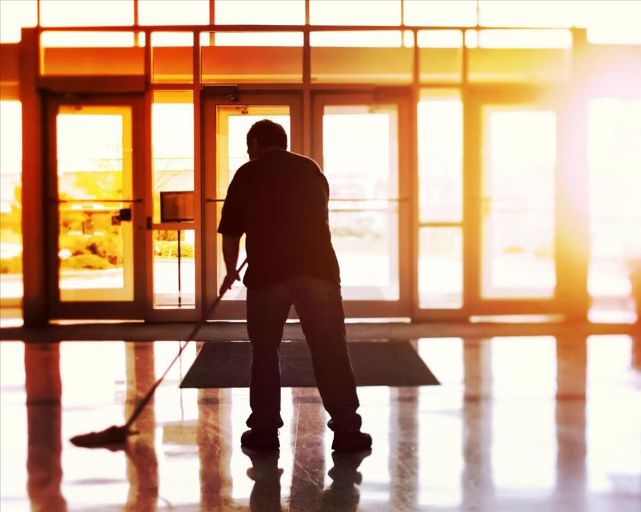 Man mopping a floor in an office building lobby