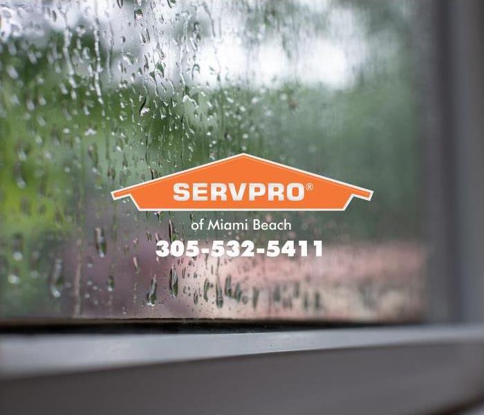 Rain is shown saturating a windowpane, seeping through a broken window seal, causing interior water damage inside a house. 