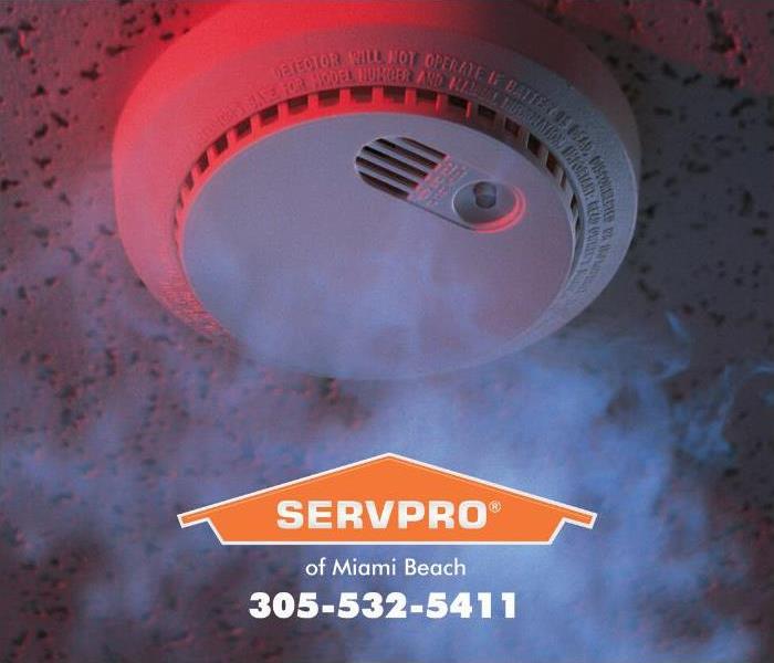 A smoke detector is blinking a red flashing light and emitting an earsplitting beeping sound to alert homeowners of the prese
